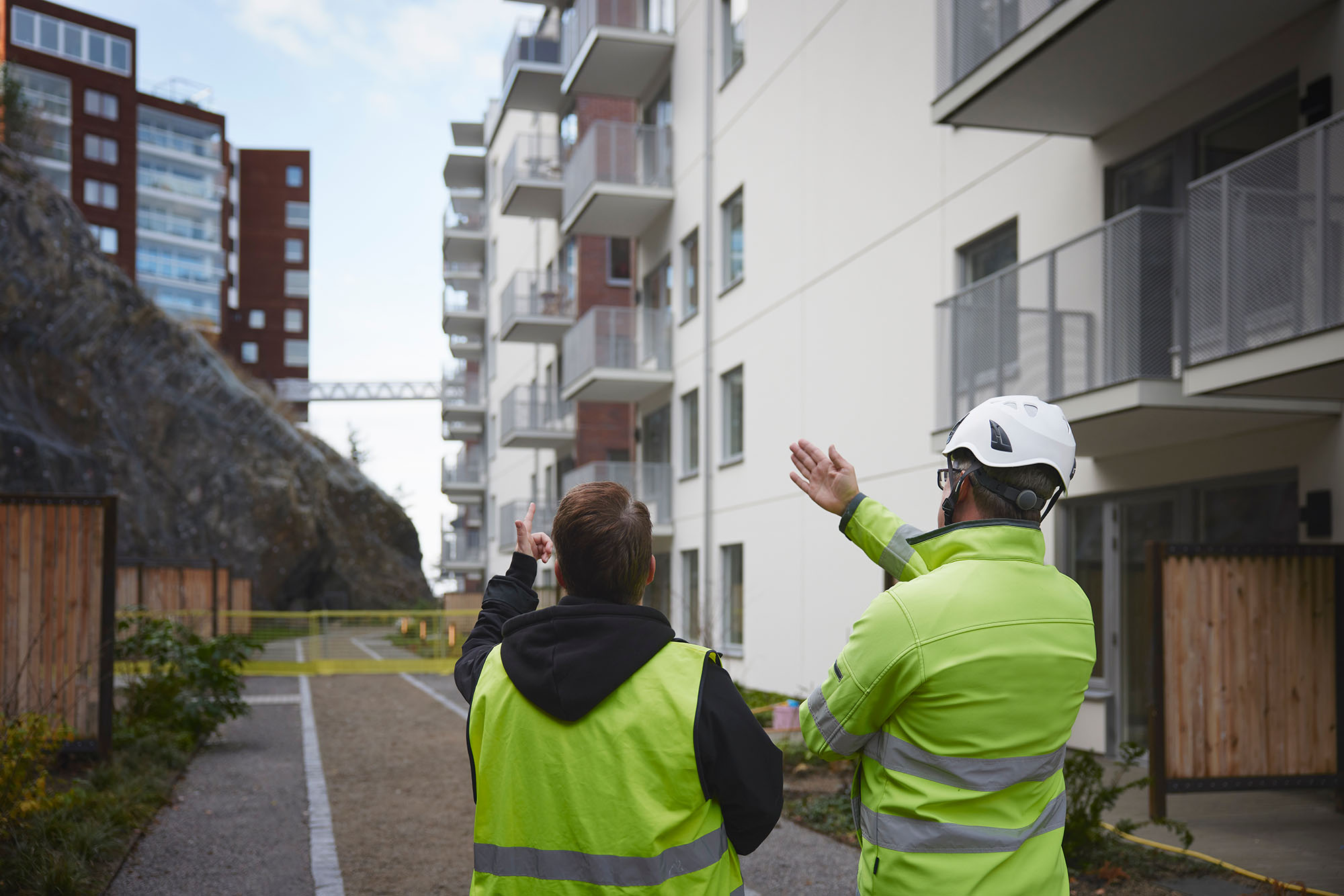 Två byggarbetare som går runt bland nyproduktioner